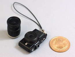 プレゼント賞品：「OLYMPUS PEN レンズ交換式ストラップ」（「E-P2」ブラック）10円玉とのサイズ比較イメージ