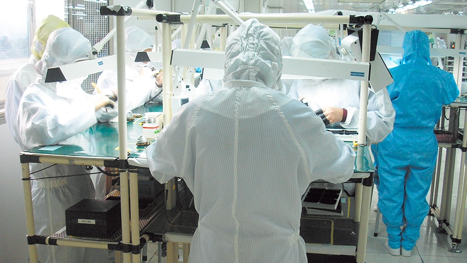 シンセン工場での「鏡枠」ユニット製造の様子。作業服を着た数人の従業員が作業を行っている。